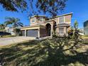 Two-story house with a three-car garage and landscaped yard at 19029 Chislehurst Dr, Land O Lakes, FL 34638