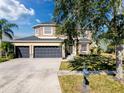 Two-story house with three-car garage and manicured lawn at 19029 Chislehurst Dr, Land O Lakes, FL 34638
