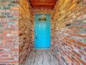 Charming teal front door entryway with brick walls at 2446 Belleair Rd, Clearwater, FL 33764