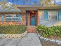 Inviting front entrance with teal door and brick columns at 2446 Belleair Rd, Clearwater, FL 33764