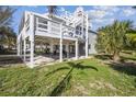 Exterior view of stilt house on luscious green property featuring multiple levels of decks and entertainment area at 3476 Tidewater Dr, Weeki Wachee, FL 34607