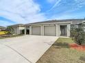 Front view of a three-unit building, with driveway and landscaping at 37804 Prairie Rose Loop, Zephyrhills, FL 33542