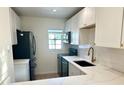 Modern kitchen with white cabinets, quartz countertops, and black appliances at 4511 S Oak Dr # R12, Tampa, FL 33611