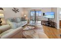 Living room with comfy seating, large TV, and access to balcony at 460 Paula S Dr # 401, Dunedin, FL 34698