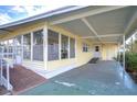 Side view of a yellow single-story home with ramp access at 6021 Ridgewood Dr, Zephyrhills, FL 33542