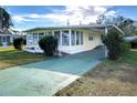 Front view of a yellow single-story home with a carport at 6021 Ridgewood Dr, Zephyrhills, FL 33542