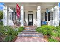 Front porch with wicker chairs, a bench, and hanging wind chimes at 10023 Brompton Dr, Tampa, FL 33626