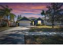 Gray house with white garage door, landscaping, at dusk at 10322 Goldenbrook Way, Tampa, FL 33647