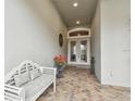 Inviting front porch with a white bench and double doors at 23 Concord Dr, Dunedin, FL 34698