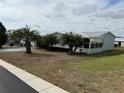 Landscaped manufactured home with a covered patio at 37729 Neukom Ave, Zephyrhills, FL 33541
