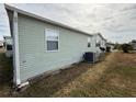 Rear view of the manufactured home with AC unit at 37729 Neukom Ave, Zephyrhills, FL 33541