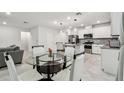Bright dining area with glass table and four white chairs at 6684 Devlin Ln, Wesley Chapel, FL 33545