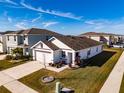 White house with brown accents, a two-car garage, and well-manicured landscaping at 682 Olive Conch St, Ruskin, FL 33570