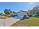 Side view of villa, showcasing garage and manicured landscaping at 1006 Mcdaniel St # 21, Sun City Center, FL 33573