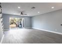 Spacious living room with sliding glass doors and hardwood floors at 13907 Fletchers Mill Dr, Tampa, FL 33613