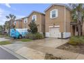 Tan townhome with attached garage, landscaping, and driveway at 17841 Althea Blue Pl, Lutz, FL 33558