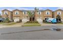 Tan three-story townhome with attached garage and landscaping at 17841 Althea Blue Pl, Lutz, FL 33558