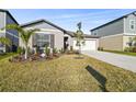 One-story house with gray siding, white garage door, and palm trees at 22103 Blazing Star Run, Land O Lakes, FL 34637