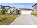 One story house with gray siding, white garage door, and neatly landscaped yard at 22103 Blazing Star Run, Land O Lakes, FL 34637