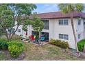 Back of condo building with chairs, table, a large tree, sliding glass doors and large screened patio at 2750 E Bay Dr # 2D, Largo, FL 33771