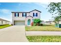 Charming two-story home featuring a well-manicured lawn, attached garage, and covered front porch at 3059 Nubbin Ridge Ln, Zephyrhills, FL 33540