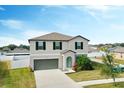 Inviting two-story home featuring a two car garage, well-maintained lawn, and landscaped garden at 3059 Nubbin Ridge Ln, Zephyrhills, FL 33540