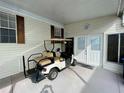 Covered patio with golf cart and entrance to the home at 34071 Avocado N Dr, Pinellas Park, FL 33781