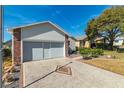 Double-car garage with concrete driveway and landscaping at 5909 Yorkshire Dr, Zephyrhills, FL 33542