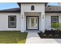 Front entrance with a glass door, white exterior, and modern lighting at 6605 24Th S Ave, Tampa, FL 33619