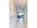 Bright entryway with tile floors, chandelier, and view into living room at 993 Anchor Bend Dr, Ruskin, FL 33570