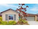 Tan house with gray shutters, landscaping, and a large tree at 993 Anchor Bend Dr, Ruskin, FL 33570