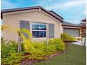 Tan house with gray shutters, landscaping, and palm trees at 993 Anchor Bend Dr, Ruskin, FL 33570