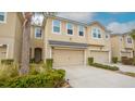 Tan three-story townhome with two-car garage and palm tree at 10108 Newel Valley Loop, Riverview, FL 33569
