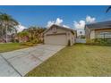 Tan house with a two-car garage and manicured lawn at 11607 Branch Mooring Dr, Tampa, FL 33635