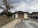 Ranch-style house with brown garage door and mature tree in front at 12812 1St Isle, Hudson, FL 34667