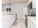 White kitchen with stainless steel appliances and tile floors at 1429 Villa Capri Cir # 306, Odessa, FL 33556