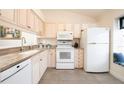 Well-equipped kitchen featuring granite countertops and white cabinetry at 158 Sun Isle Cir, Treasure Island, FL 33706
