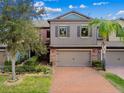 Two-story townhome with a brick driveway and lush landscaping at 17284 Old Tobacco Rd, Lutz, FL 33558