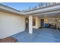 Carport with gray floor, bicycle, and trash cans at 1752 Atrium Dr, Sun City Center, FL 33573