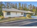 Light beige house with gray roof, small patio furniture, and carport at 1752 Atrium Dr, Sun City Center, FL 33573
