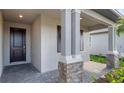 Covered front porch with stone columns and a dark brown front door at 2009 Gardenia Ave, Port Charlotte, FL 33953