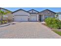 Two story house with a two car garage and brick accents at 3091 King Fern Dr, Wimauma, FL 33598