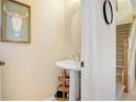Small powder room with pedestal sink and round mirror at 310 Summer Clouds Pl, Brandon, FL 33511