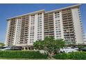 Front view of a high rise building with lush landscaping at 400 Island Way # 309, Clearwater Beach, FL 33767