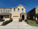 Two-story townhome with tan siding, a two-car garage, and landscaping at 4073 71St N Ter, Pinellas Park, FL 33781