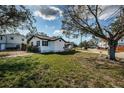 A charming white one-story home with black shutters and trim and a well-manicured lawn at 6254 Pershing Ne St, St Petersburg, FL 33702