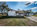 Inviting single-story home showcasing a covered front porch and a connected carport for convenient parking at 6254 Pershing Ne St, St Petersburg, FL 33702