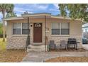 Tan block house with brown door, small front yard, and driveway at 652 13Th S Ave, St Petersburg, FL 33701