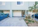 Front view of a light teal townhouse with a two-car garage and landscaping at 657 Garland Cir, Indian Rocks Beach, FL 33785