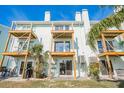 Rear view of three-unit townhouse with decks and lush landscaping at 657 Garland Cir, Indian Rocks Beach, FL 33785